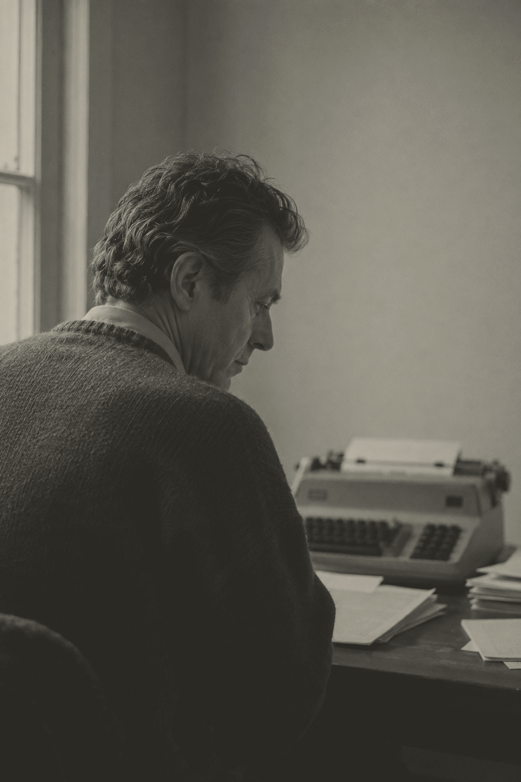 Arthur Sterling seated at a typewriter beside a window